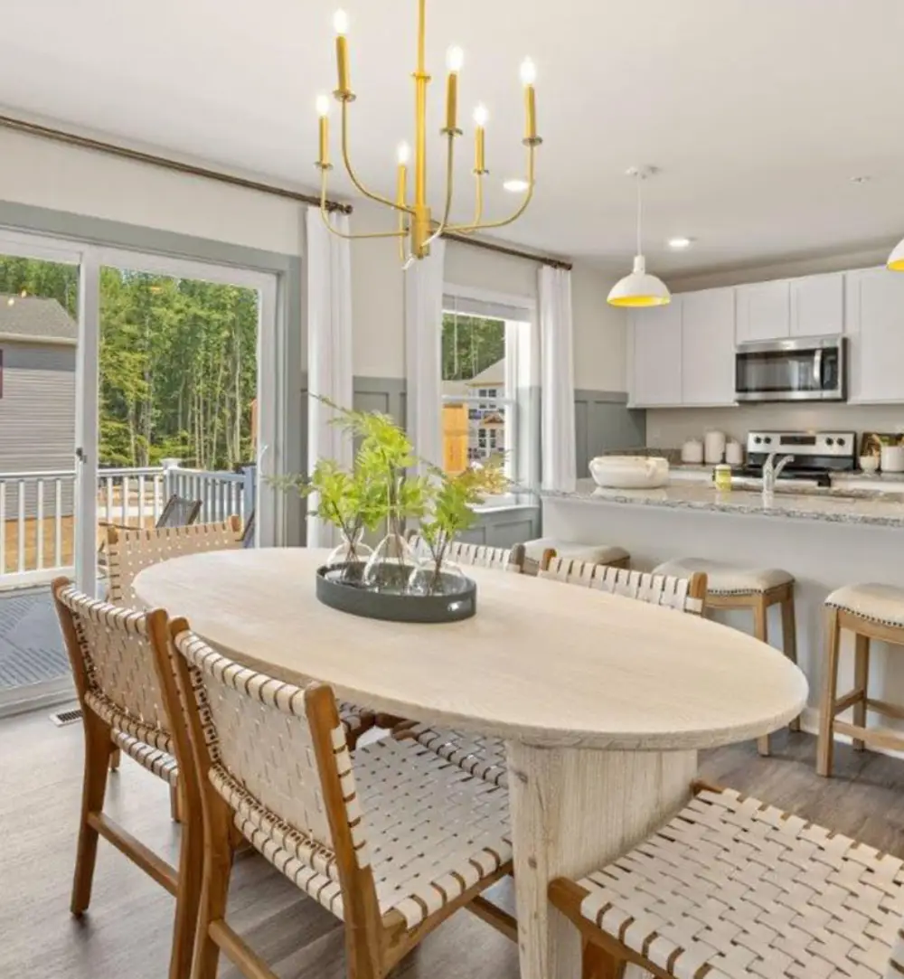 Bright dining room with round table and pendant lighting.